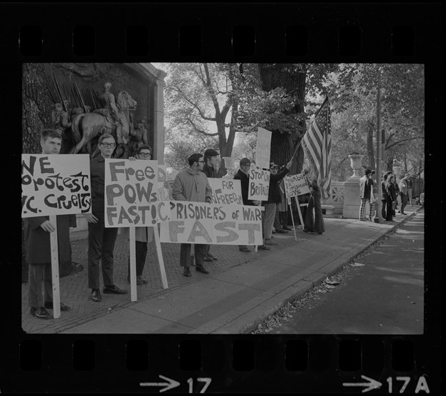protesters lined up in front of the Shaw Memorial during vigil for POWs