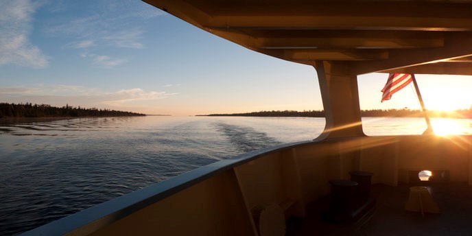 a view from the ranger iii deck looking out over the water at sunset