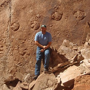 vince standing at large fossil trackway