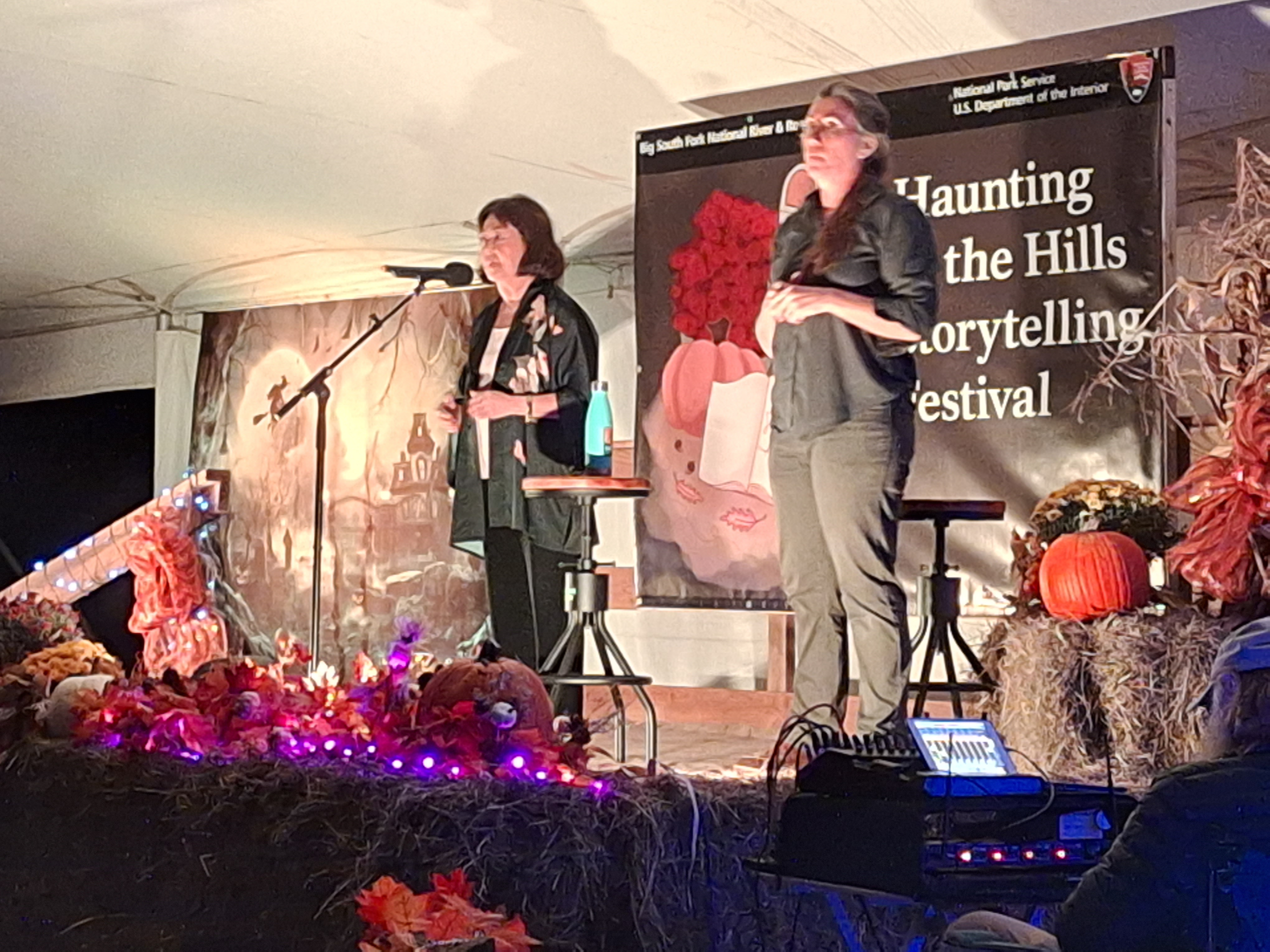 A storyteller and interpreter standing on stage from a previous event.