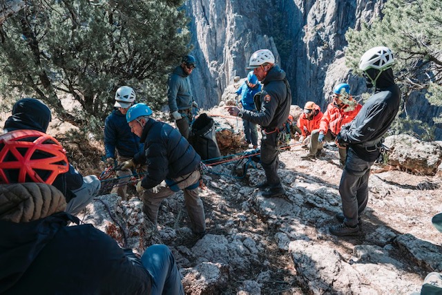 rescue team at top of dramatic canyon prepare ropes for rescue