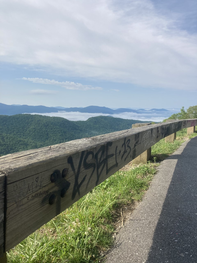 graffiti Words and images drawn on a wooden guard rail along the Parkway