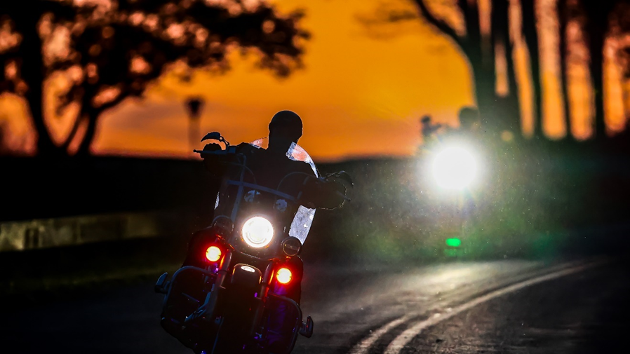 Motorcycle riders riding at sunset