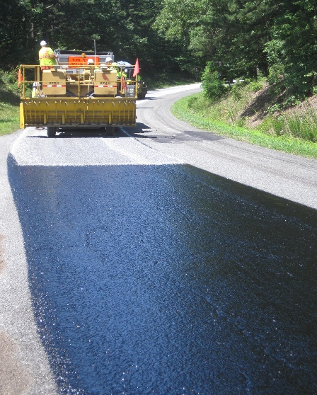 A paving machine lays down a new layer of pavement on the motor road.