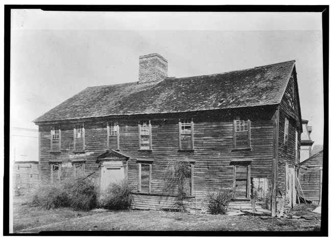 Wood-framed 2 1/2 story building with center chimney