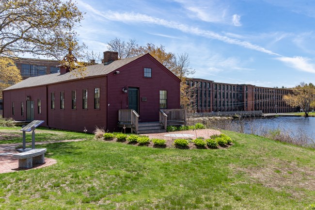 Red building in front of mill pond