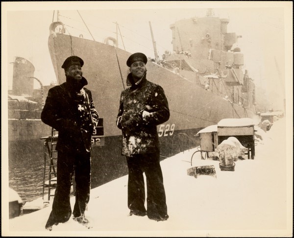 Two USS Mason Sailors on the pier near their ship in a snowstorm