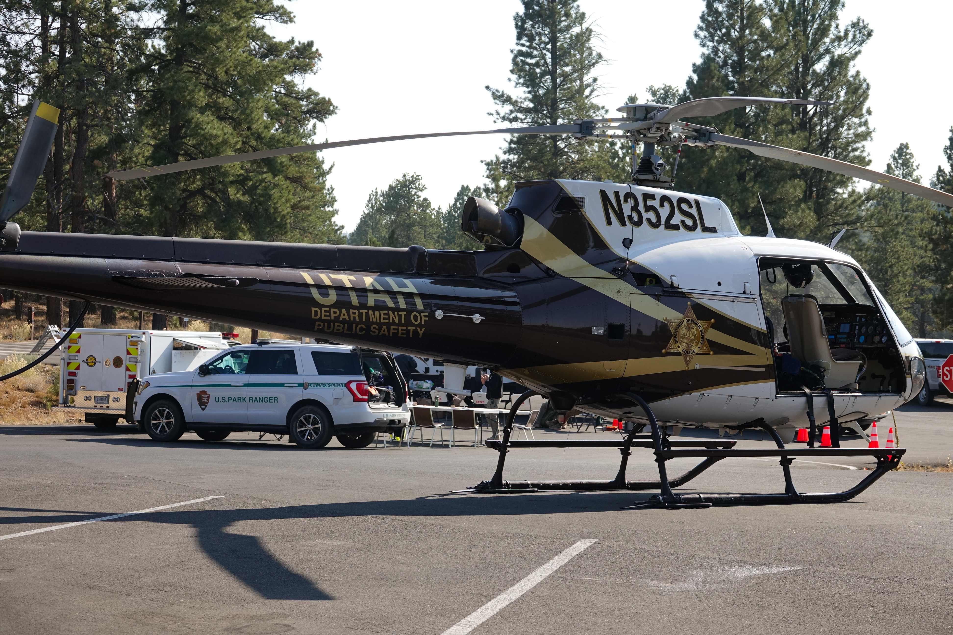 Helicopter, Park Ranger, and Search and Rescue vehicles in parking lot