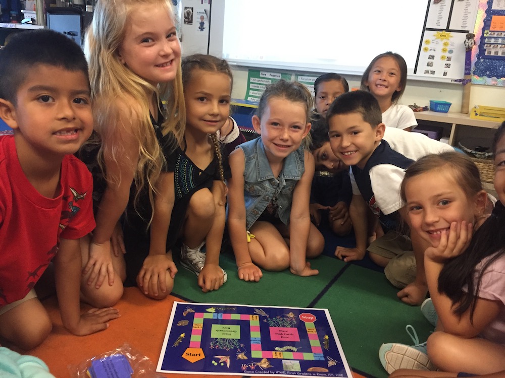 Students show off their board game exploring the life cycle of the peregrine falcon