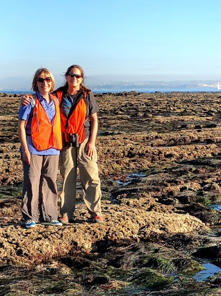 Two volunteers smiling for the camera in the tidepools at Cabrillo National Monument.