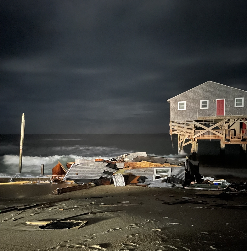 Photo taken during nighttime hours showing house collapse debris.