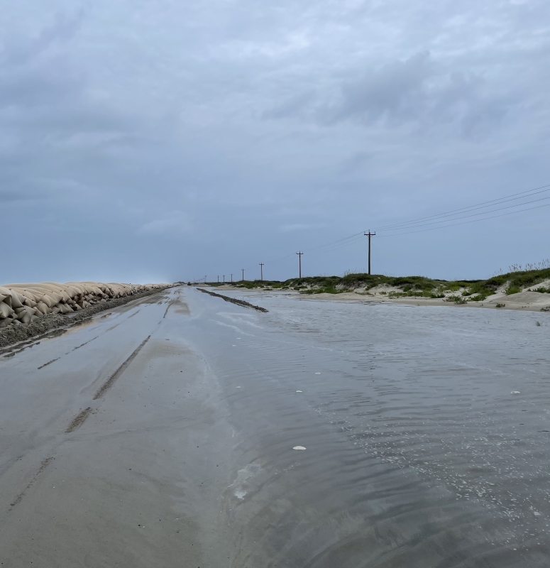 Photo showing ocean overwash on highway near north end of Ocracoke Island.