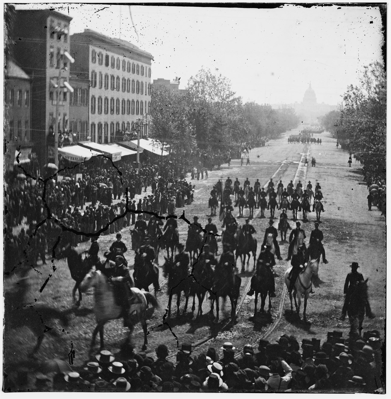 US soldiers march up Pennsylvania Avenue with spectators lining the street of Washington DC in May 1865.