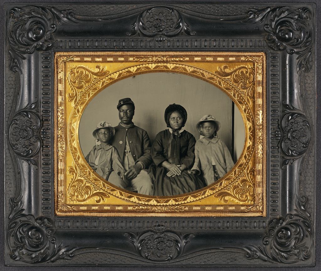 Portrait of African American soldier, Samuel Smith, with his wife and two children.