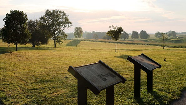 Pair of waysides with rolling grassy fields beyond