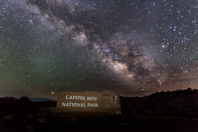 The Milky Way floats above the Capitol Reef entrance sign.