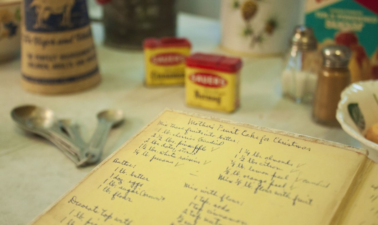 Image of an open recipe book with a handwritten recipe for fruit cake.