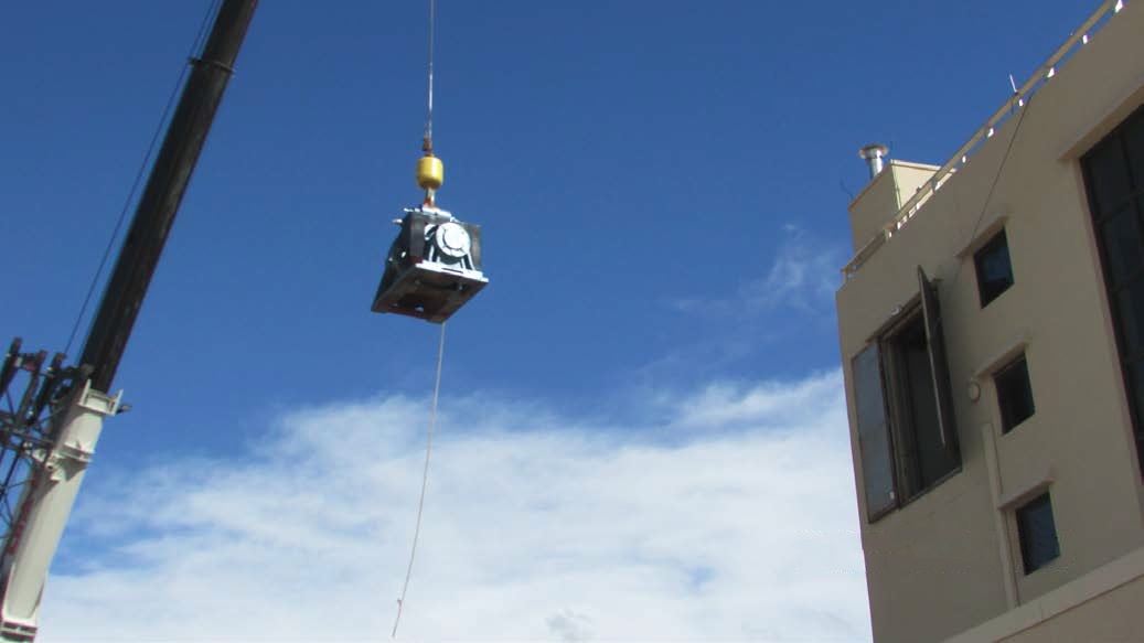 Photo of crane hoisting new elevator motor