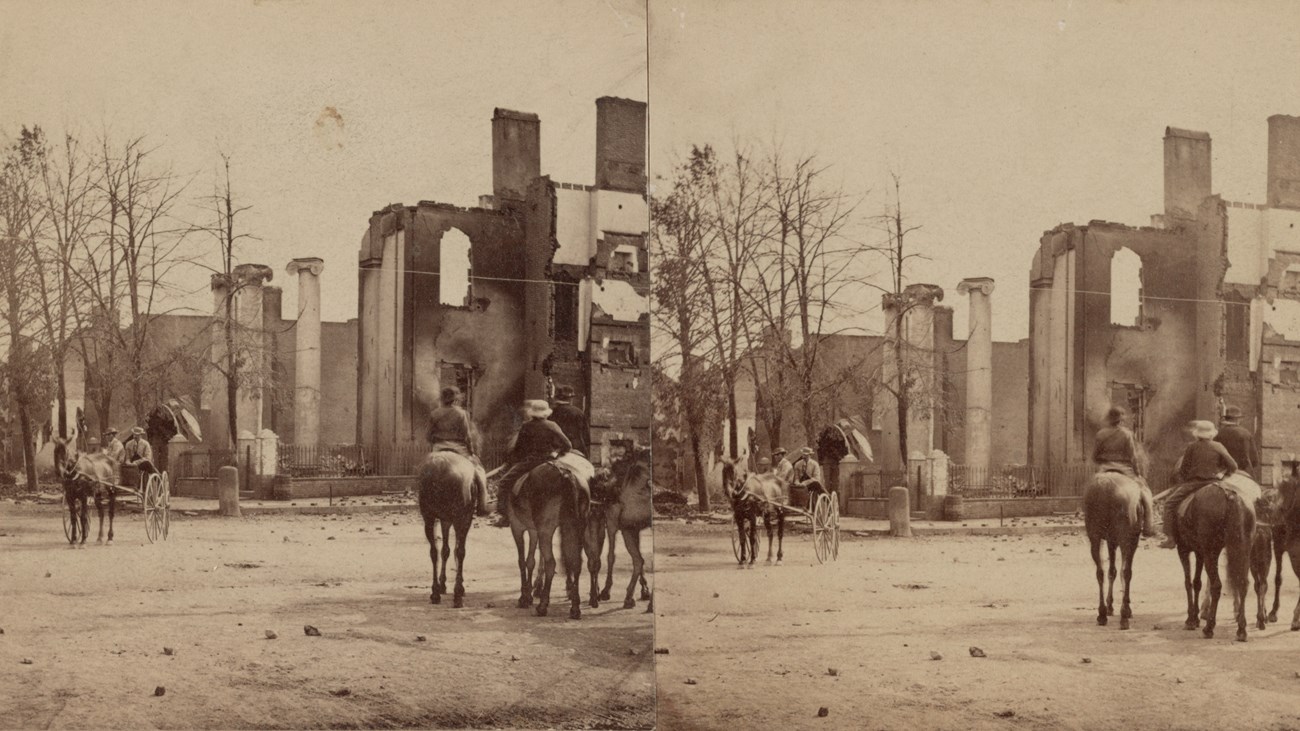 An 1864 stereograph captures mounted men looking at a burned bank.