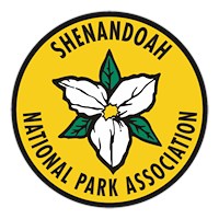 A yellow circular logo with a white magnolia flower for Shenandoah National Park Association.