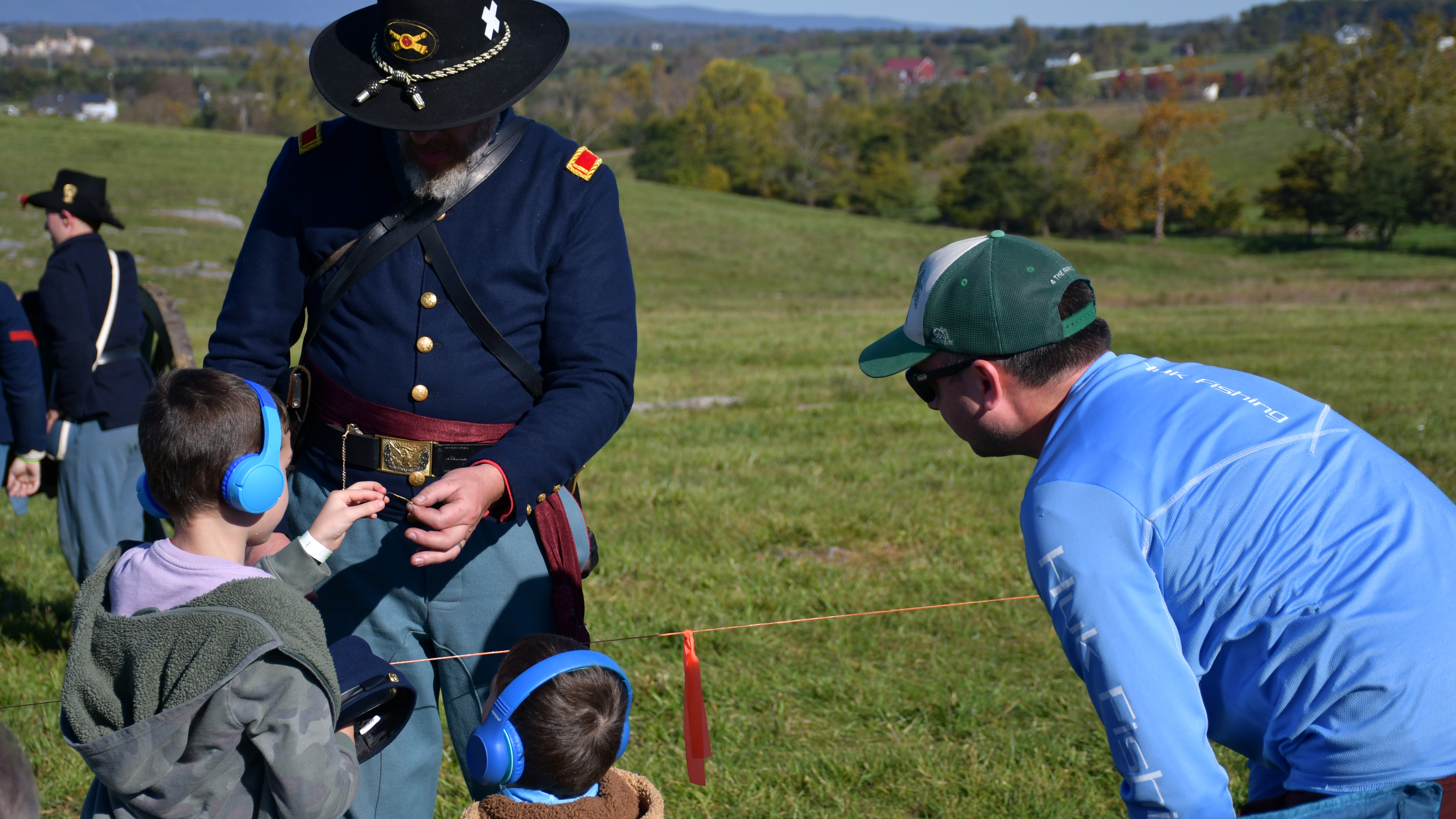 Civil War living historian talks with two children.