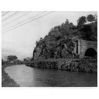 Black & white photograph of the Point of Rocks railroad tunnel next to the C&O Canal filled with water.