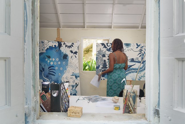 photograph of Crucian artist La Vaughn Belle painting in her studio