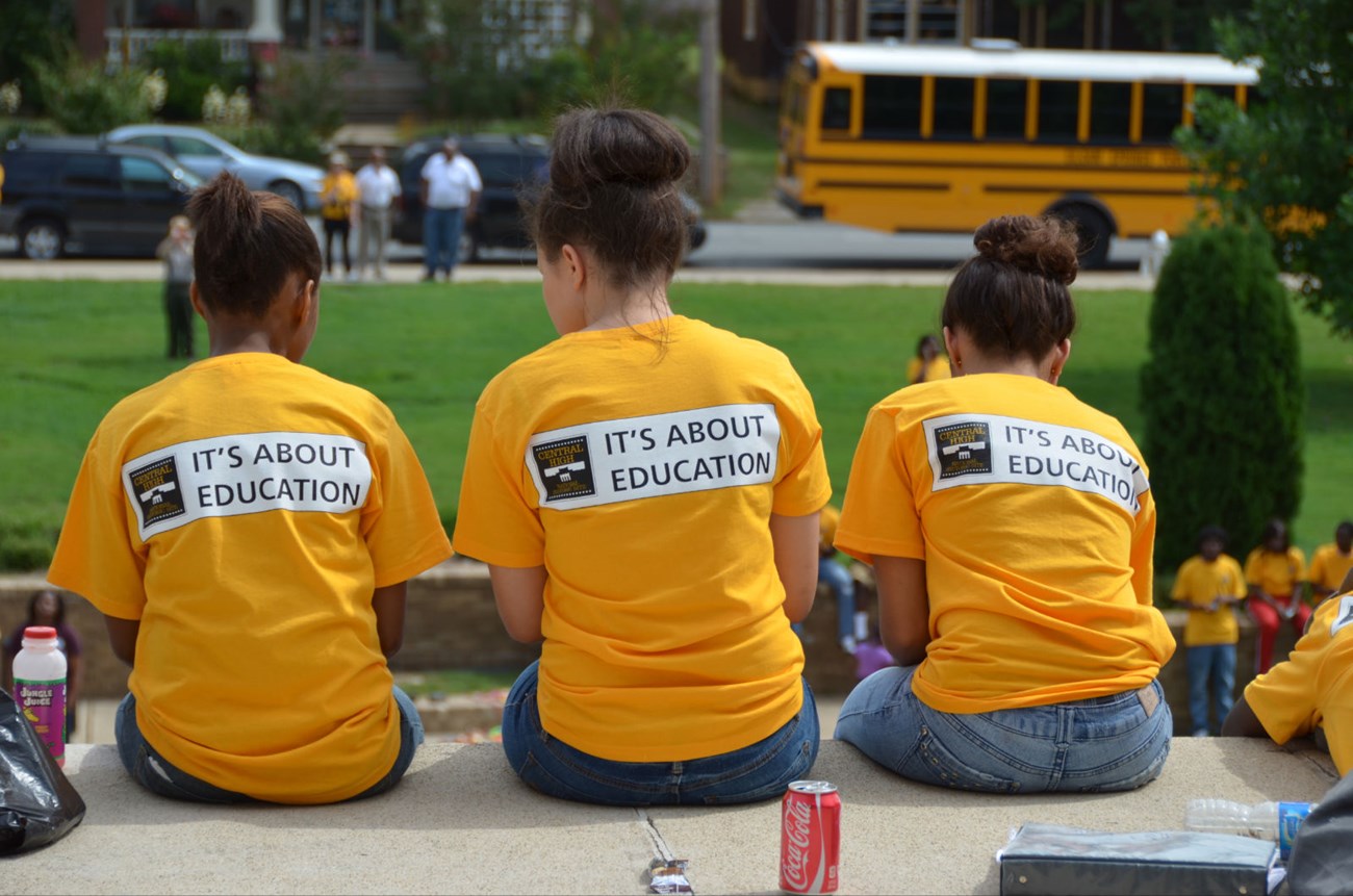 Students at Central High School sit outside the school's main entrance.