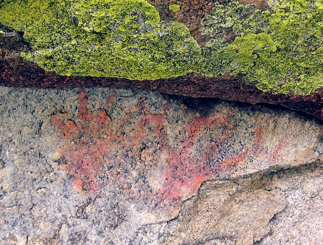 Orange colored pictograph on granite thought to depict antlers, looks almost like two hand prints.
