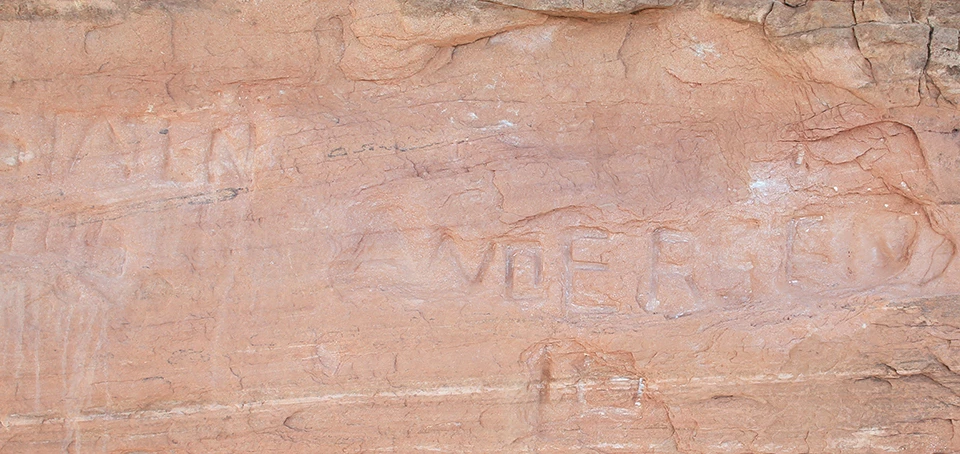 a rock wall with carved letters in it