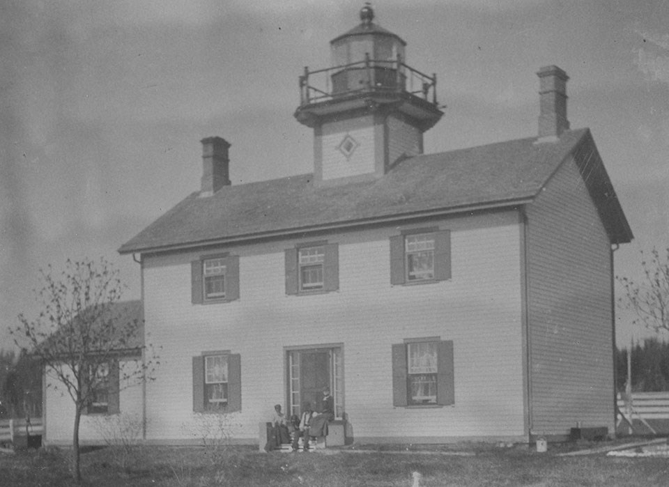 Two story white house, single home style, with a lighthouse tower on the center of the roof.