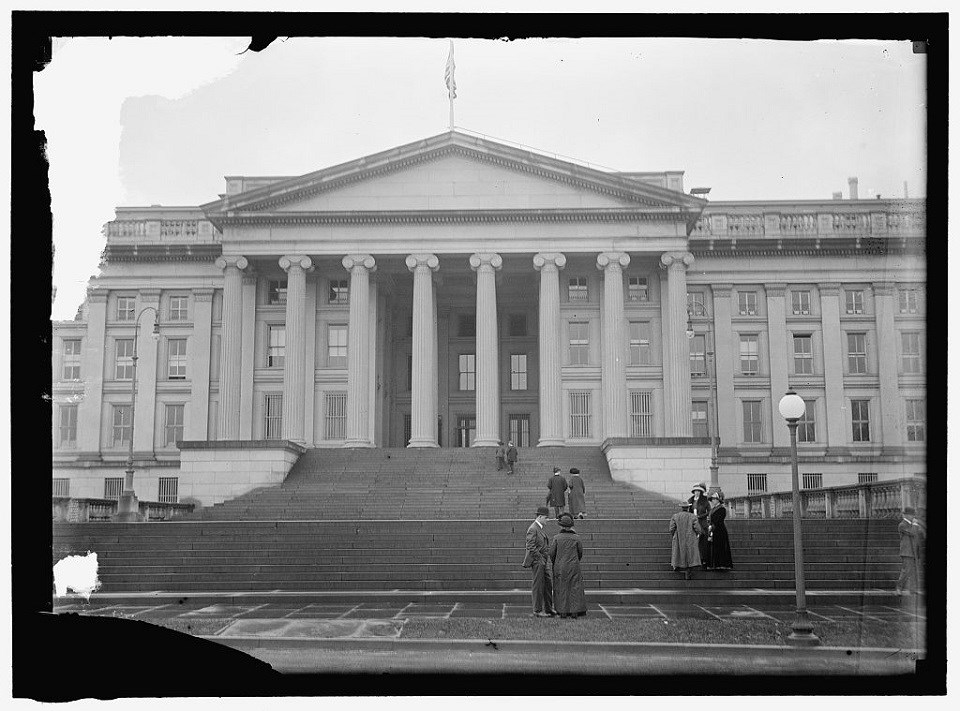 Black and white photo of the Treasury building with white stairs and stone columns