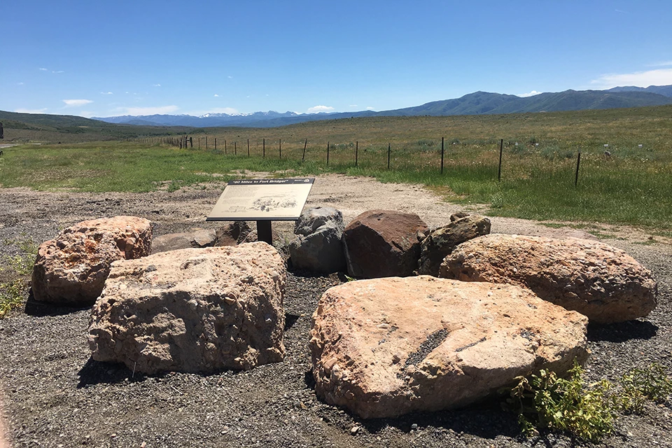 A view looking out onto a field of grass and a distant mountain range.
