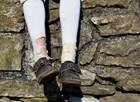 legs and feet with worn leather shoes