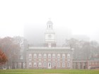 Front view of Independence Hall with the clock tower shrouded in mist.
