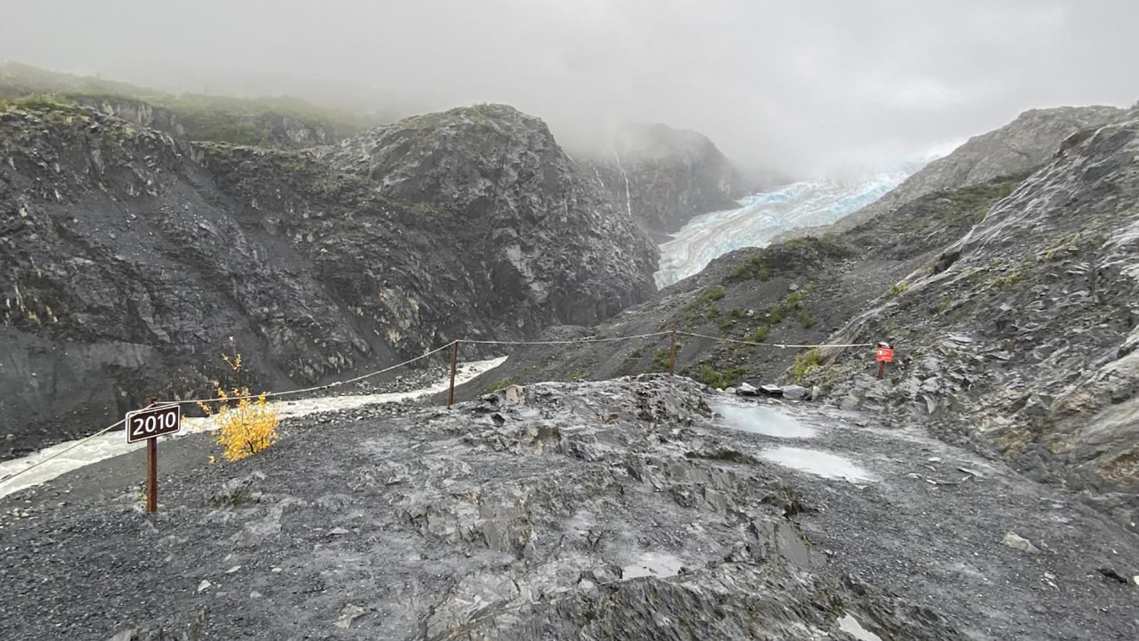 A on the left of the image says 2010. Behind it a glacier is in the center between two mountains.