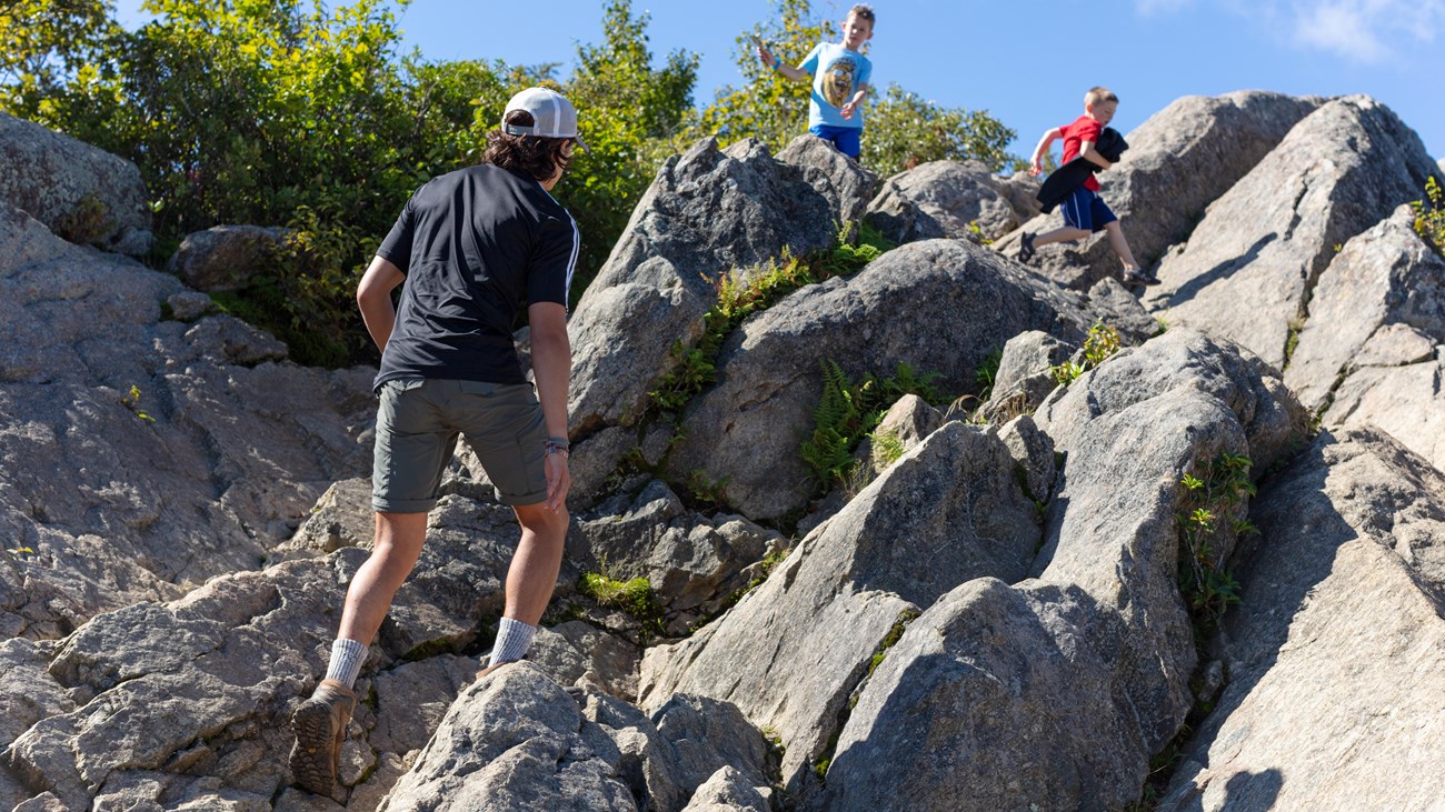 Hikers traverse large boulders at the summit of Marys Rock