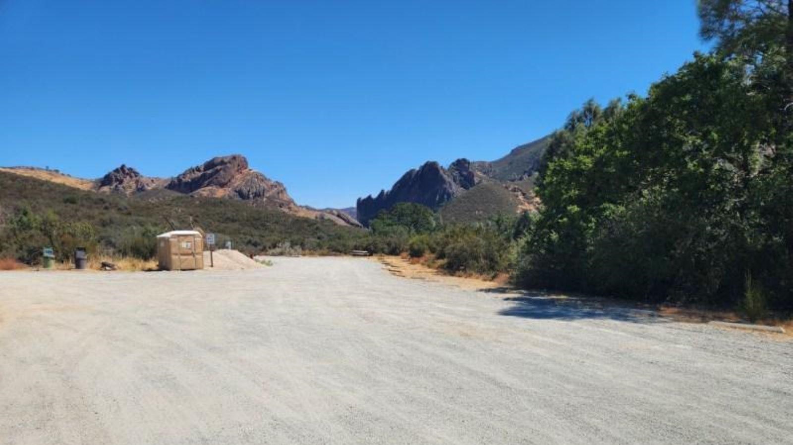 Gravel parking area with views of rock formations.