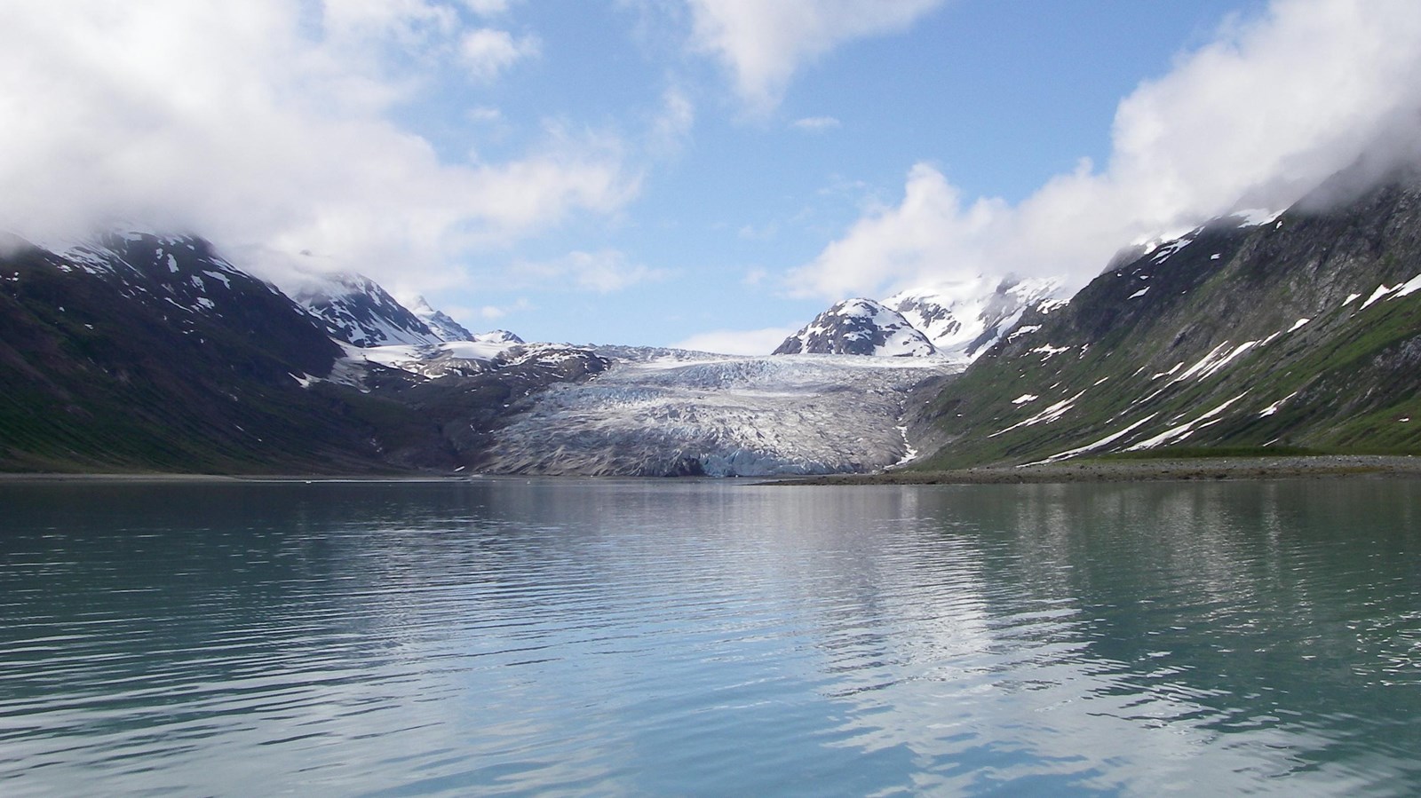 The distant, sloped face of Reid Glacier as seen from the mouth of Reid Inlet on a clear day.