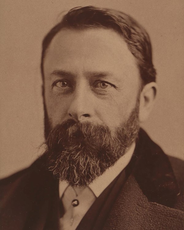 A head and shoulders portrait of a bearded man.