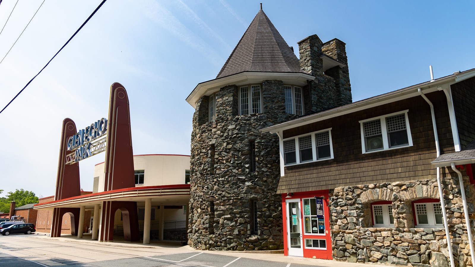 A stone turret with three floors and a pointy, shingled roof.
