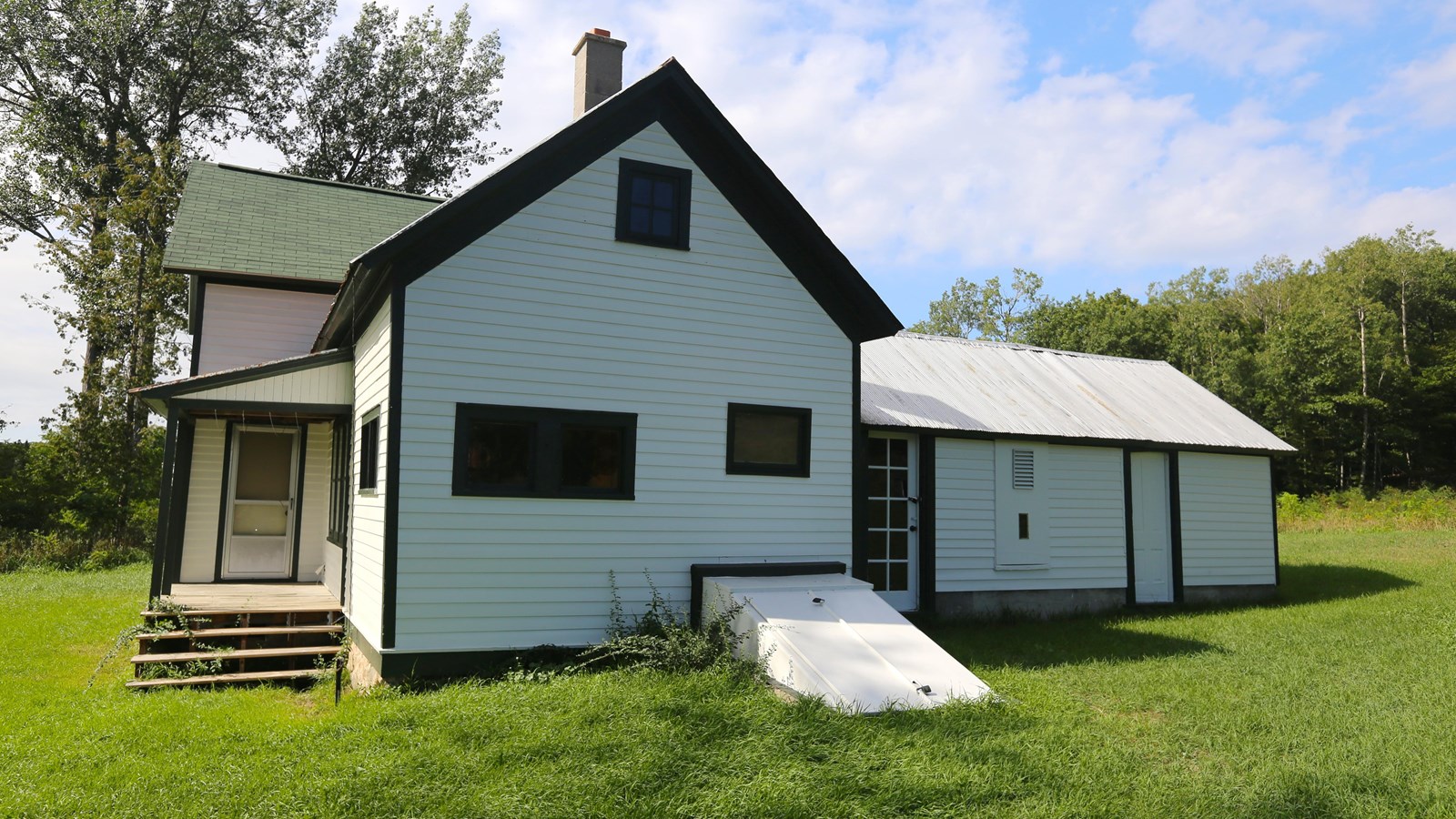 White, gabled farmhouse with dark green trim