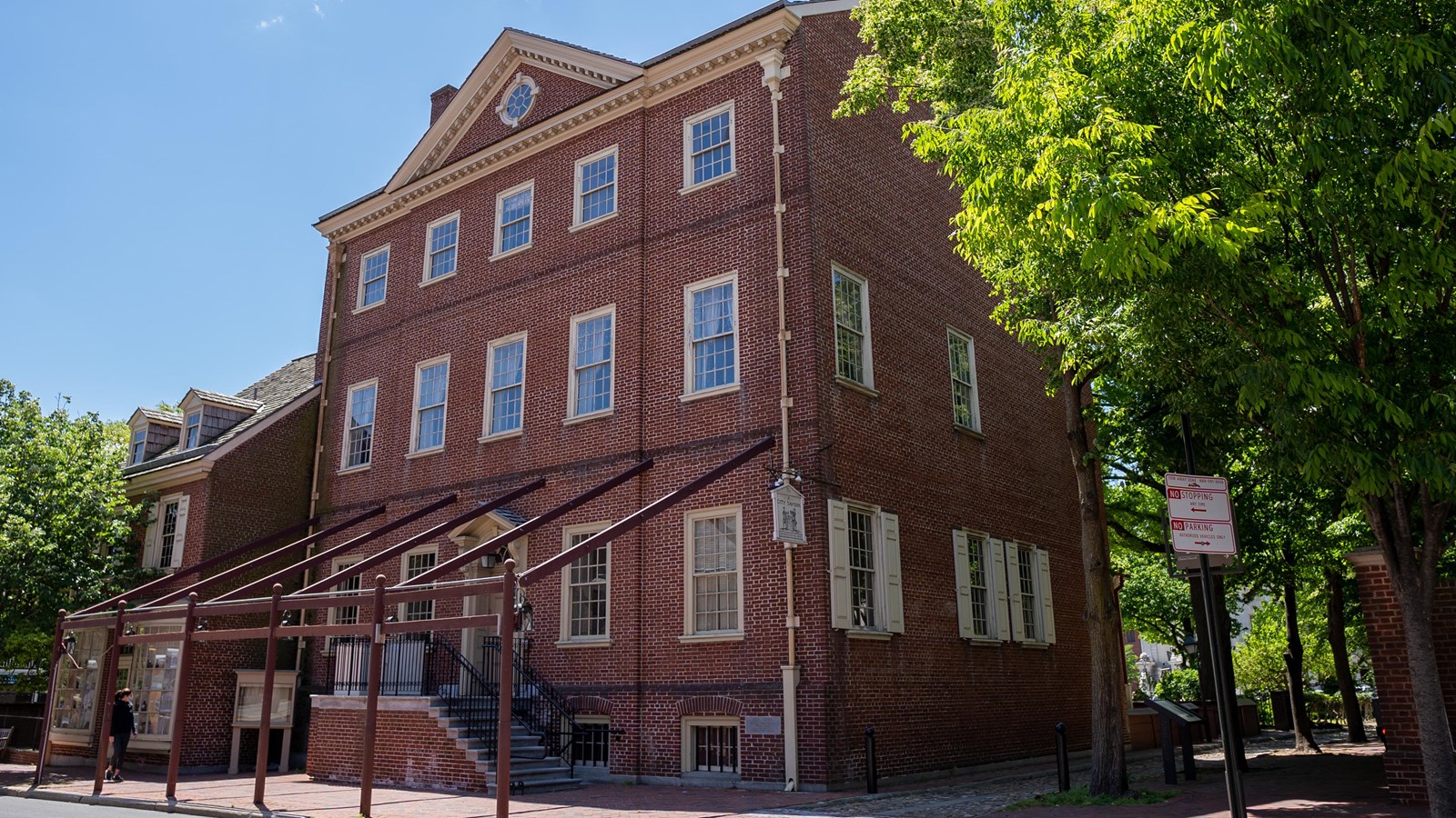 Exterior view of three story red brick building with numerous windows on each level.