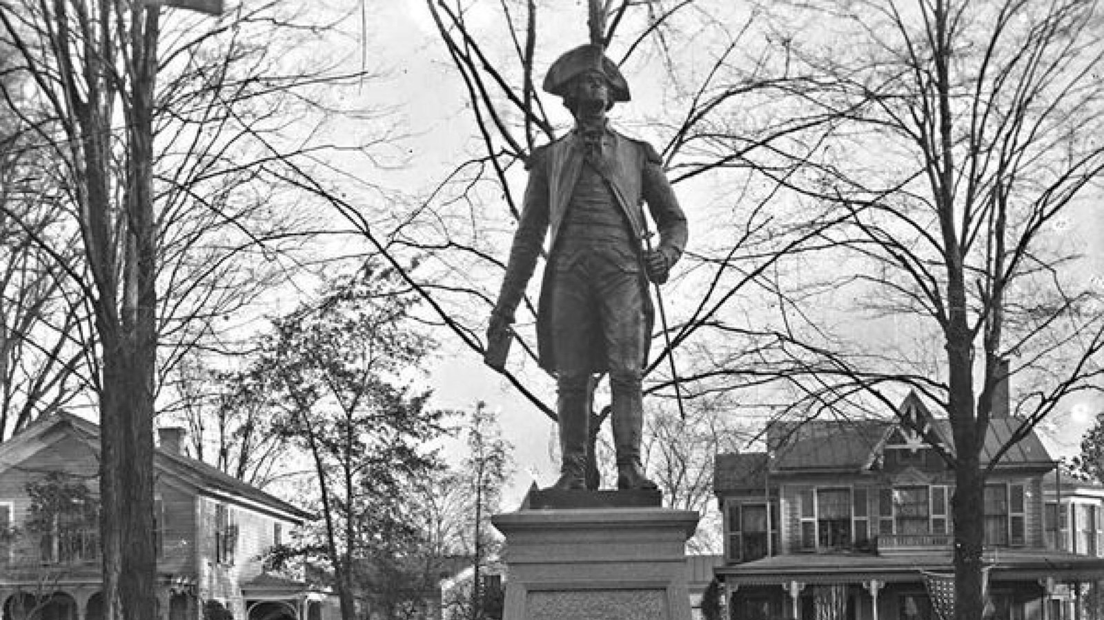A large granite block with a brass figure of a man in Continental solider uniform on top.