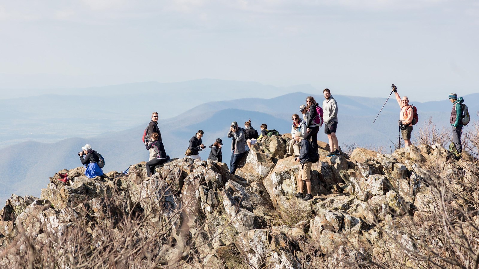 A color photograph of people on the summit of Stony Man, some joyously facing the camera.