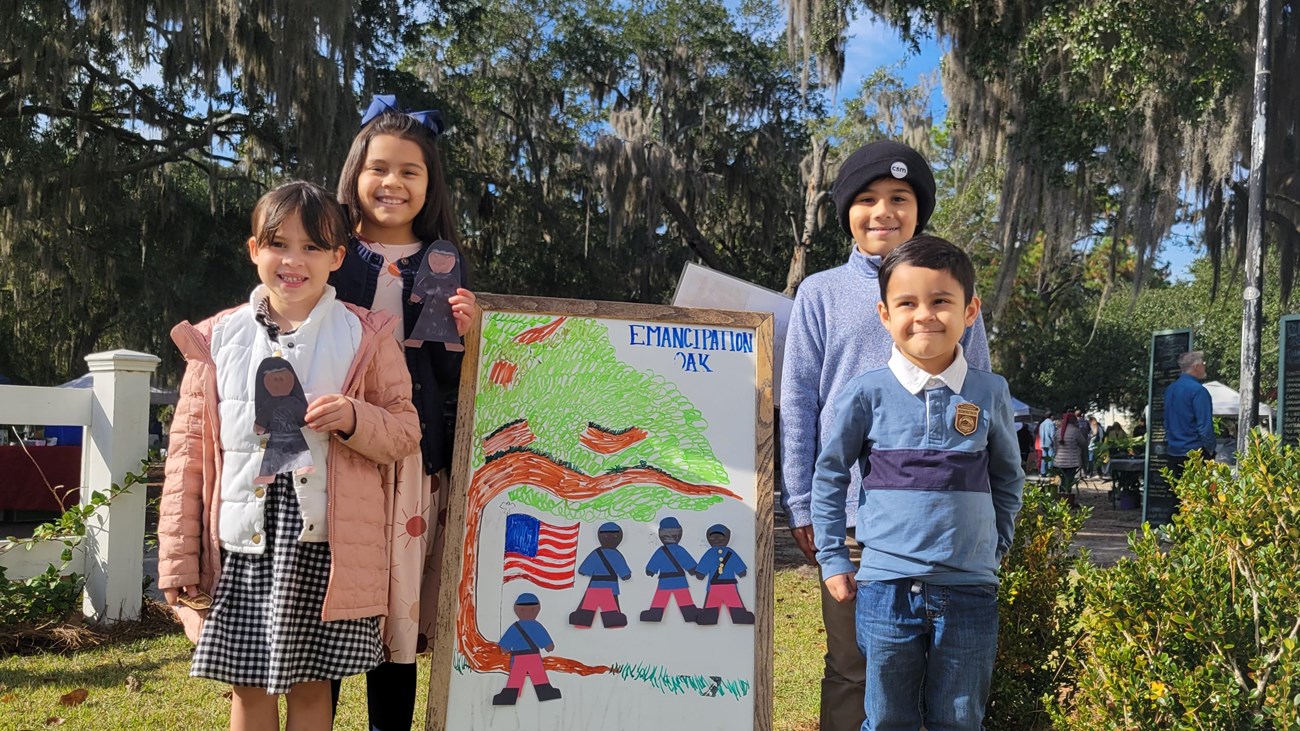 A group of four kids with their Junior Ranger badges and crafts.