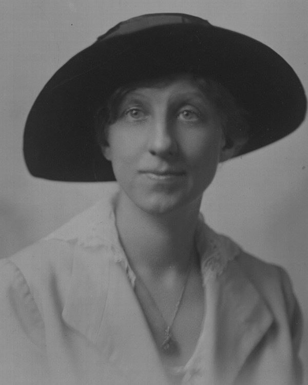 A black and white image of a women wearing a hat. 