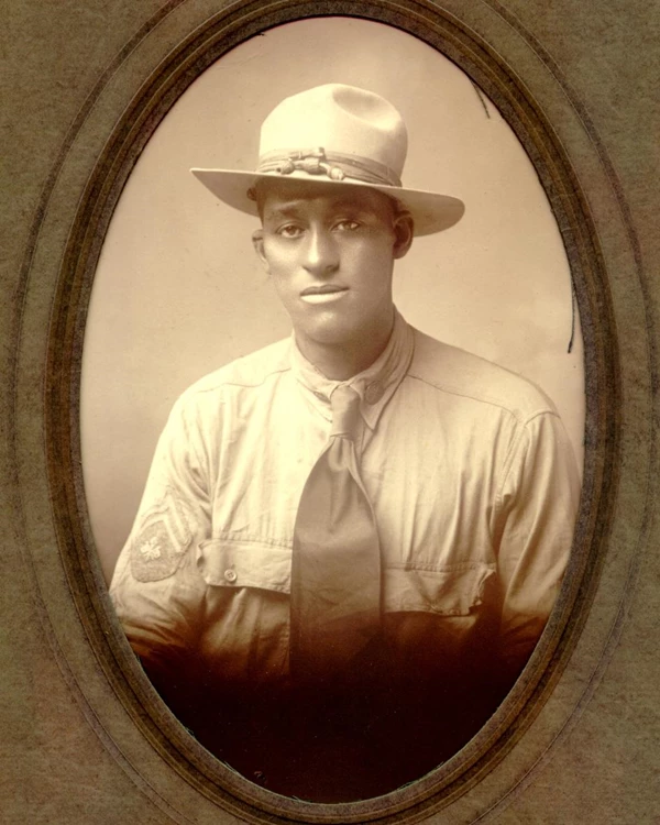 Russell Walker seated in a button-down shirt, tie and army ranger hat