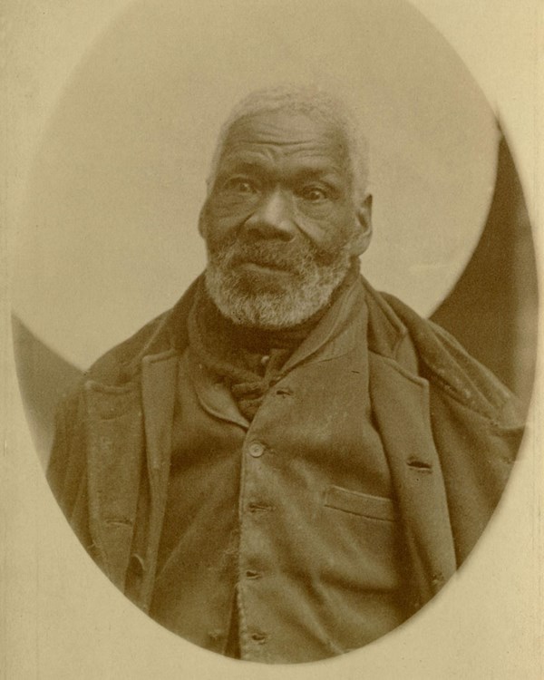 An old Black man, Gabriel, sitting for a photo.