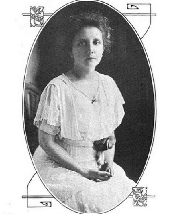 A black & white photograph of a young Mabel Lloyd Ridgely, sitting in a white dress.